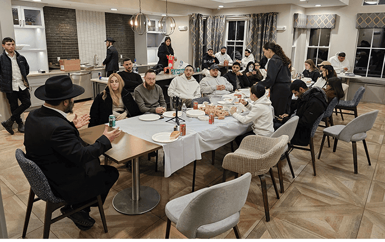 Rabbi Shlomo Noginski dining with guests at Chabad House Boston