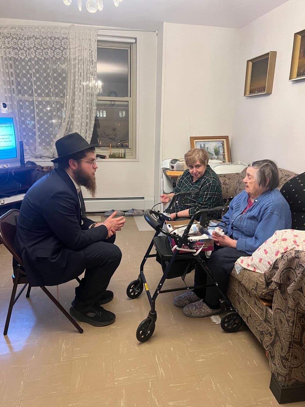 A young man visiting and talking with an elderly woman
